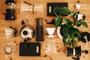 Best Way to Make Coffee - Alternative coffee brewing method set, flat lay. Stylish accessories and items for alternative coffee on wooden table. Kettle, scales, geyser, grinder, aeropress, pour over, glass flask top view