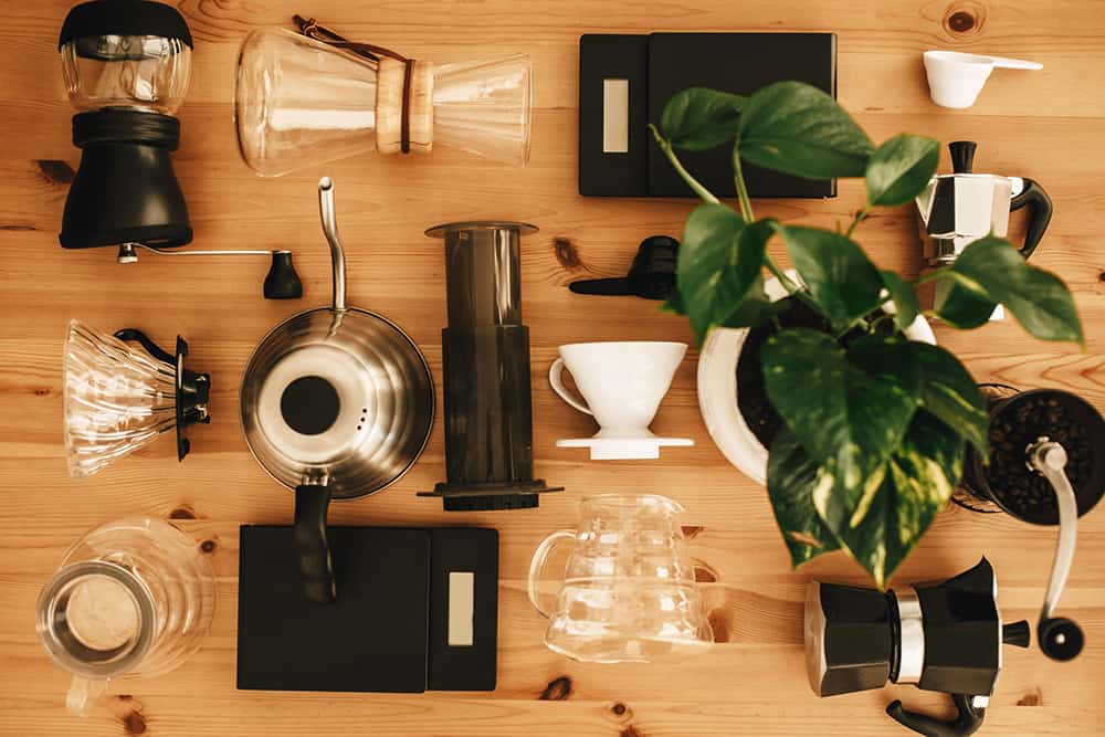 Best Way to Make Coffee - Alternative coffee brewing method set, flat lay. Stylish accessories and items for alternative coffee on wooden table. Kettle, scales, geyser, grinder, aeropress, pour over, glass flask top view